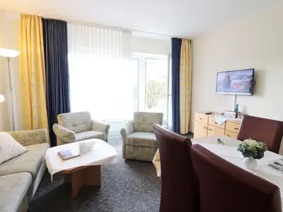 Wohnzimmer mit TV, Couch und Esstisch