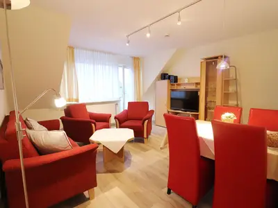 Wohnzimmer mit Esstisch, Sofa und TV
