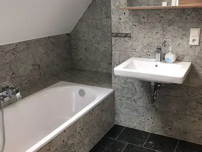 Badezimmer mit Badewanne, ebenerdiger Dusche und WC