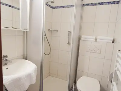 Badezimmer mit Dusche und Handtüchern