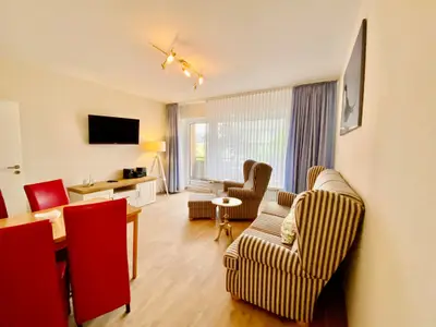 Wohnzimmer mit TV, Balkon, Couch und Esstisch
