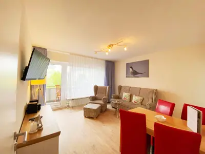 Wohnzimmer mit Esstisch, Sofa und TV