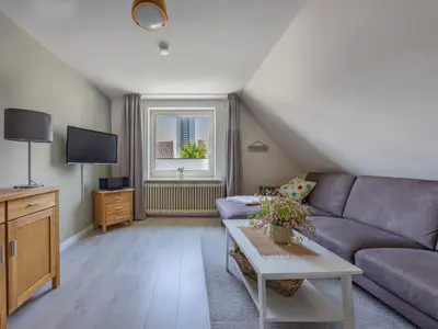 Wohnzimmer mit Fernseher und Sofa