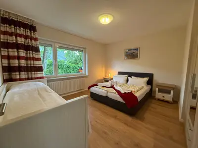 Doppelbett und Einzelbett; Nachttisch und Tischleuchte, Kleiderschrank