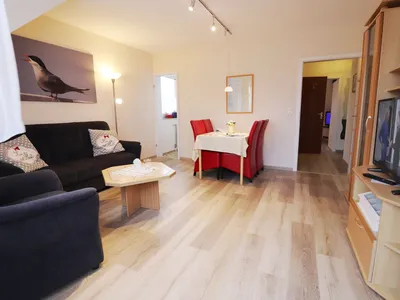 Wohnzimmer mit Sofa und Esstisch und TV