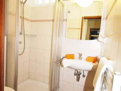 Badezimmer mit Dusche und Waschbecken, sowie Toilette, Handtücher inkl.
