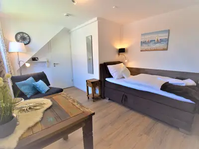 Wohn- und Schlafraum mit Bett und Essbereich