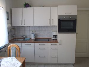 Die Küchenzeile mit Geschirrspüler, Backofen, Cerankochfeld (4) und Kühlschrank m. Gefrierfach
