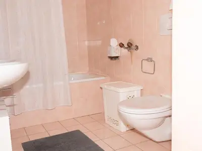 Badezimmer mit Badewanne und Doppel-Lavabos