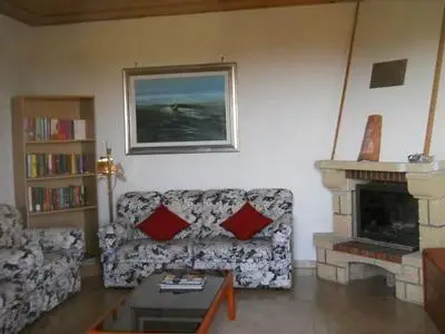 eine Ecke vom Wohnzimmer mit Kamin, Bibliothek und ein gemütliches Sofa und Sessel eine Oase entspannen