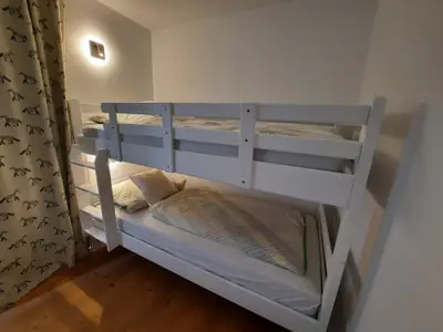 Etagenbett mit Vorhang vom Wohnbereich abgetrennt