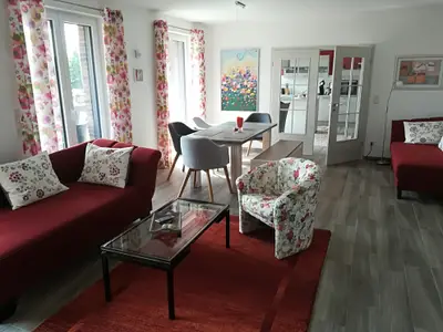 Der helle Wohnraum mit Esstisch und Schlafsofa