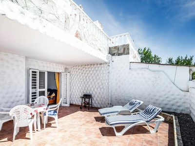 Terrasse mit Grill und Gartenmöbeln.