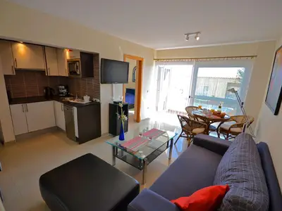 Wohnbereich. Wohnzimmer mit Balkonzugang und offener Küche