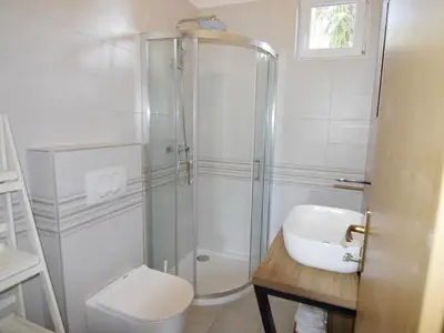 Das Badezimmer mit Dusche, Waschbecken und Toilette.