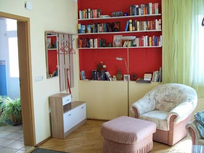 Garderobe und Bücherwand mit Lesesessel