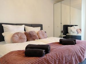 Schlafzimmer mit großem Bett und Spiegelschrank