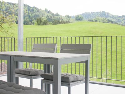 gedeckte Terrasse mit Sitzgelegenheit und Blick ins Grüne