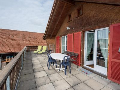 grosse, private Terrasse mit Esstisch und Liegestühlen