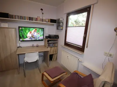 Schlafzimmer mit Relaxsessel und TV
