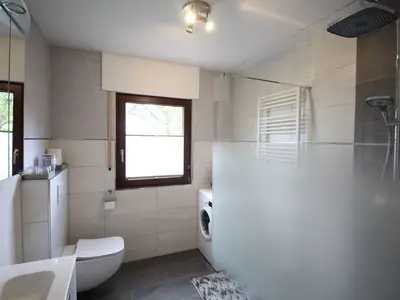 Badezimmer mit Regendusche und Waschmaschine