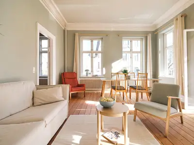 Wohnzimmer mit Couch, Esstisch und TV