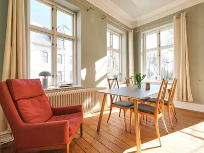 Wohnzimmer mit Couch, Esstisch und TV