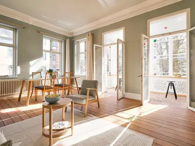 Wohnzimmer mit Couch, Esstisch und TV