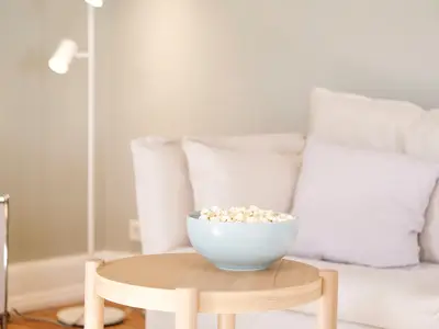 Wohnzimmer mit Couch, Esstisch und TV