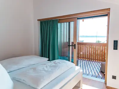Das Doppelbett mit Blick auf den See und Balkon