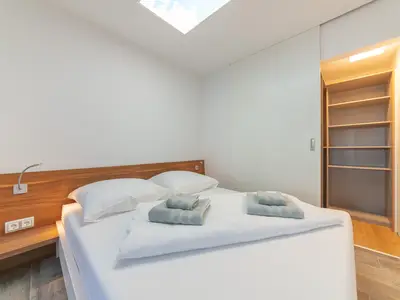 Schlafzimmer mit Doppelbett 160cm, dimmbaren Leseleuchten und Schiebetür zur Ankleide