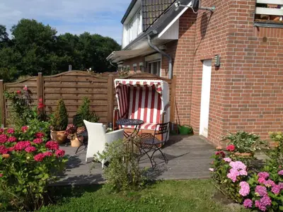 Sonnige Terrasse mit Strandkorb