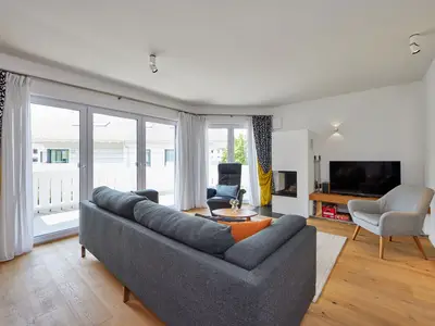 Wohnzimmer mit Fenstertüren zum Balkon