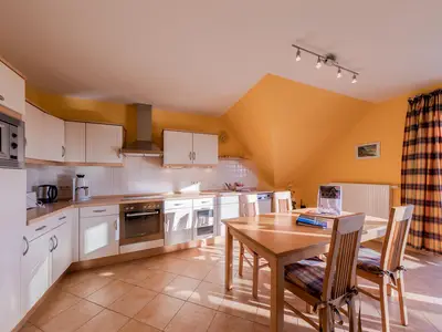 Ferienwohnung Storchenhorst Blick auf die Küchenzeile mit Essbereich