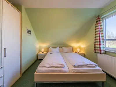 Ferienwohnung Storchenhorst eines der Schlafzimmer mit Doppelbett