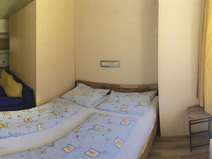 Schlafzimmer mit Doppelbetten und Couche