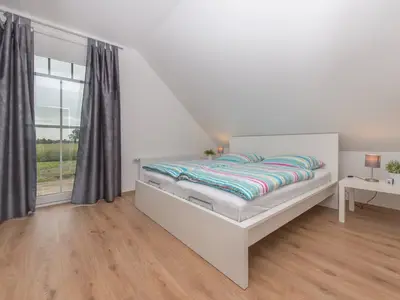 Schlafzimmer mit Doppelbett und Fernseher