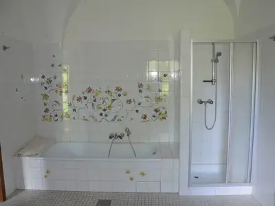 Badezimmer mit Badewanne und Dusche