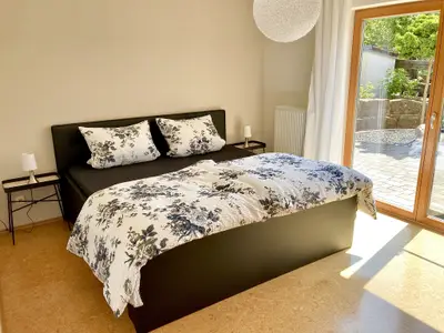 Schlafzimmerblick von der Zimmertüre, Terrassenzugang mit Fliegengitter, Vorhänge und Rolladen sind vorhanden