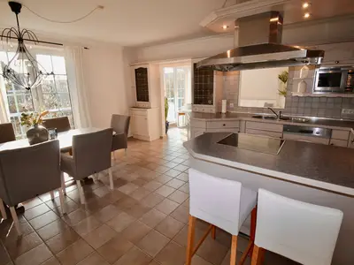 HAMPTONS HOUSE: Einladende Wohnküche mit großem Esstisch für gesellige Stunden an der Ostsee.