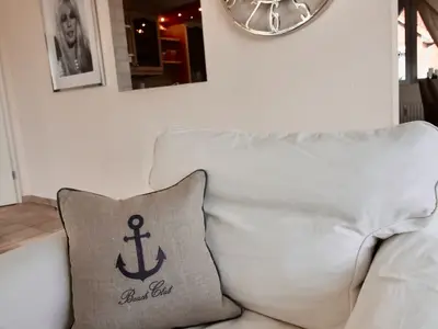 HAMPTONS HOUSE: Gemütliche Sofaecke mit maritimen Details für entspannte Ostsee-Momente.