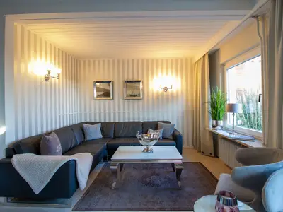 Nautic Lounge – Beach View: Helles Wohnzimmer mit großer Couch, stilvollem Interieur und Ostseeblick.