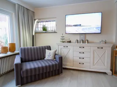 Nautic Lounge – Beach View: Gemütlicher TV-Bereich mit Schlafsessel und maritimem Flair.