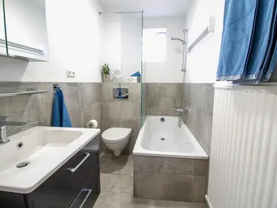 Nautic Lounge – Beach View: Modernes Bad mit Dusche, Badewanne und stilvollem Design.