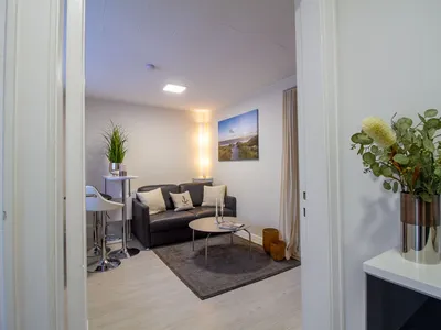 Heller Wohnbereich der Nautic Lounge – Beach House 2 mit modernem Sofa, gemütlicher Sitzecke und stilvoller Dekoration.