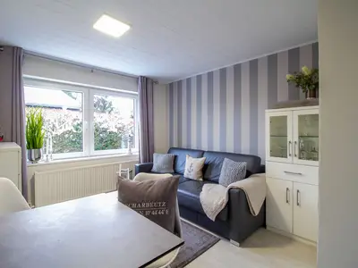 Heller Wohnbereich der Nautic Lounge – Beach House 1 mit Sofa, Fensterfront und maritimer Einrichtung.