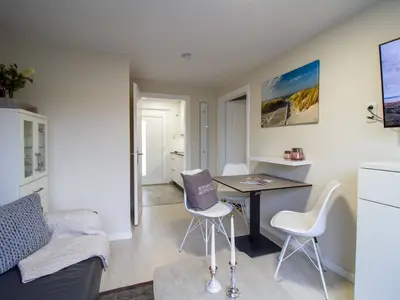 Essbereich der Nautic Lounge – Beach House 1 mit Blick zur Küche und maritimen Details an der Wand.