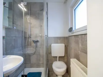 Modernes Tageslichtbad der Nautic Lounge – Beach House 2 mit Dusche und WC.