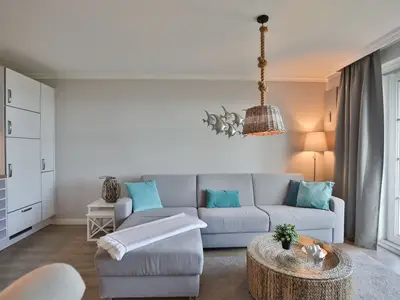Strandmuschel Haffkrug: Gemütliches Sofa und stilvolle Deko für entspannte Urlaubsmomente.