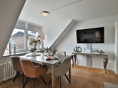 Nautic Lounge – Sea View: Moderner Essbereich mit großem Tisch, stilvoll dekoriert und TV.